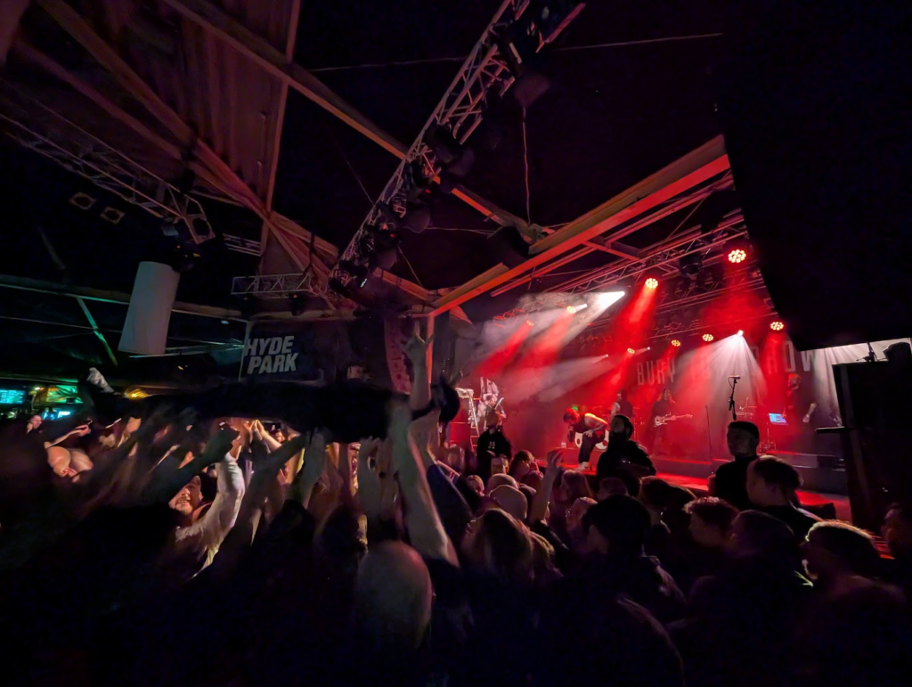Bury Tomorrow en el escenario. Una persona surfeando.